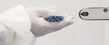Gloved hand holding pills